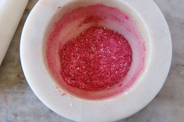 crushed freeze-dried raspberries and sugar in a mortar with pestle to the side