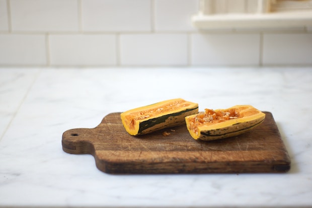 Delicata squash on cutting board cut in half