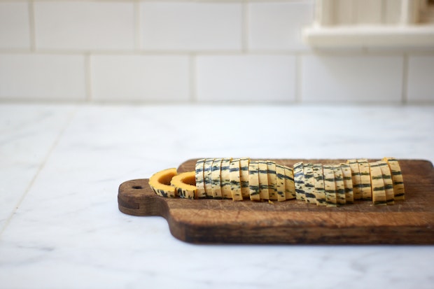 Delicata squash sliced thinly prior to roasting for topping orzo pasta