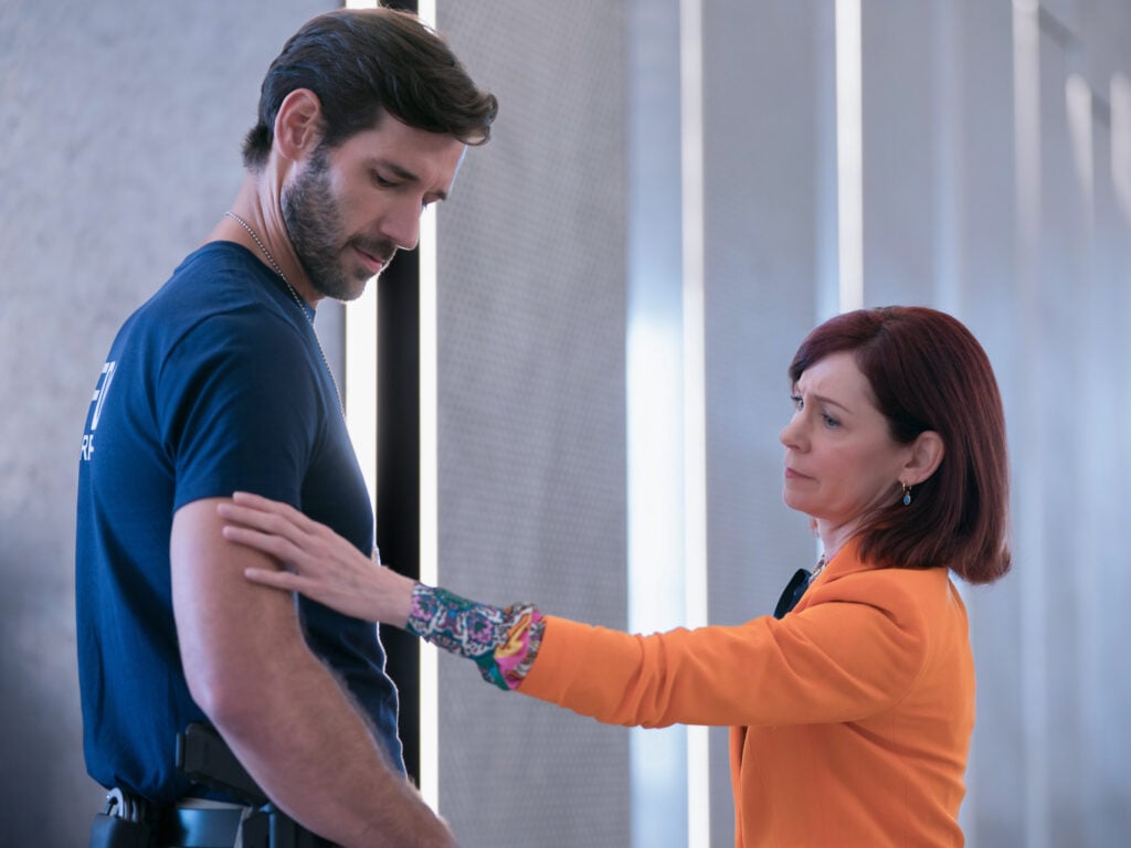 John Behlmann as Fire Marshal Jake Turning and Carrie Preston as Elsbeth Tascioni