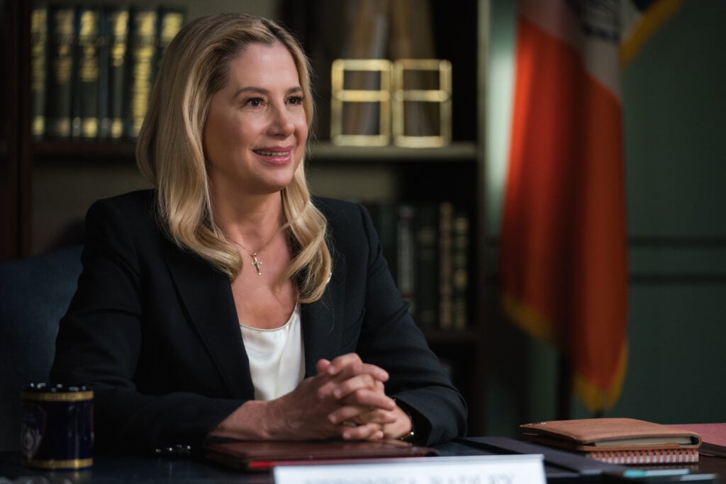 The new Fire Commissioner (Mira Sorvino) clasping her hands while sitting behind her desk on Blue Bloods Season 14 Episode 13