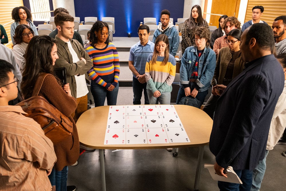 Alec's class gathers round for a demonstration using large playing cards on The Irrational Season 2 Episode 2