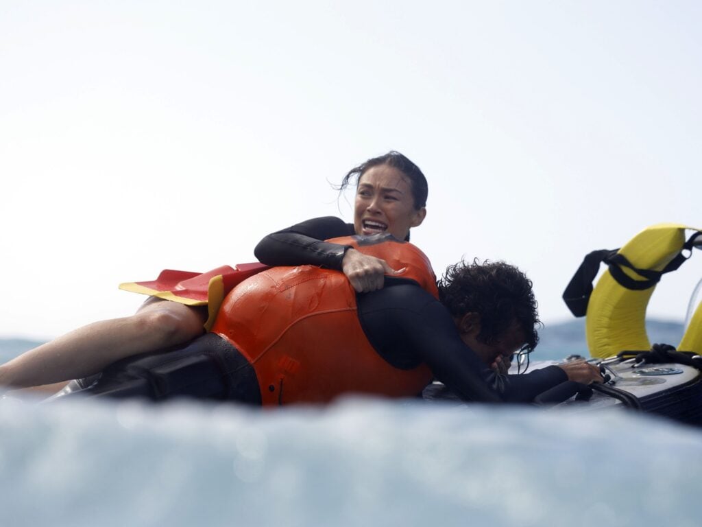 Hina hangs onto a surfer that needs help during Rescue: HI-Surf Season 1 Episode 5.