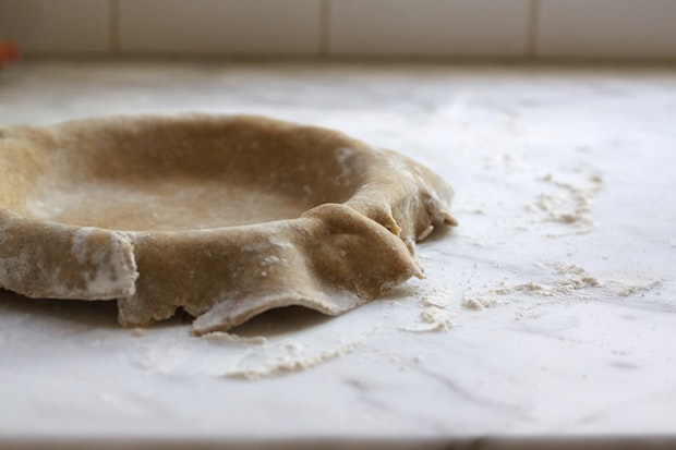 Pie Dough Draped over a Pie Plate in a Kitchen