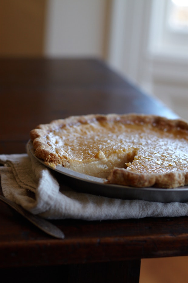 Buttermilk Pie cooling in a Pie Plate on a Wood Table