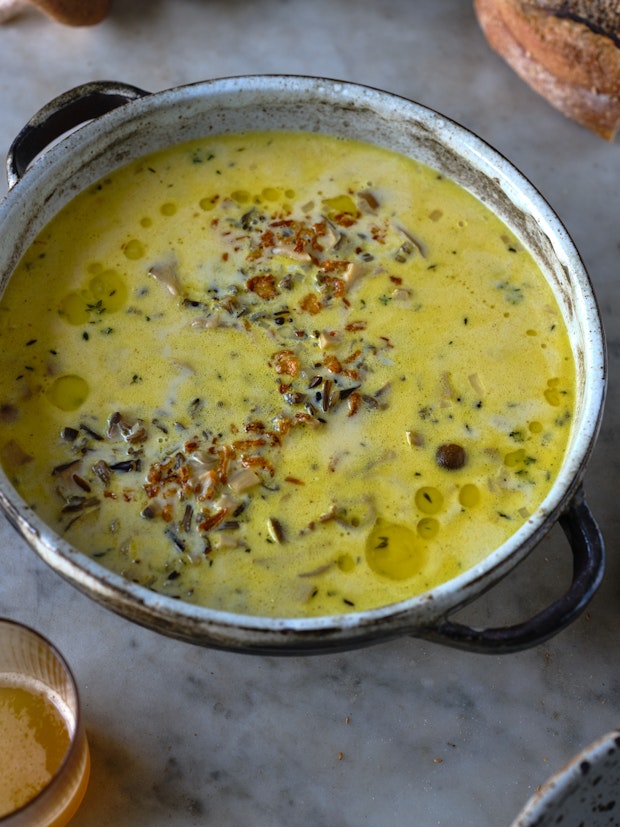 A pot of creamy wild rice soup in a rustic pot.