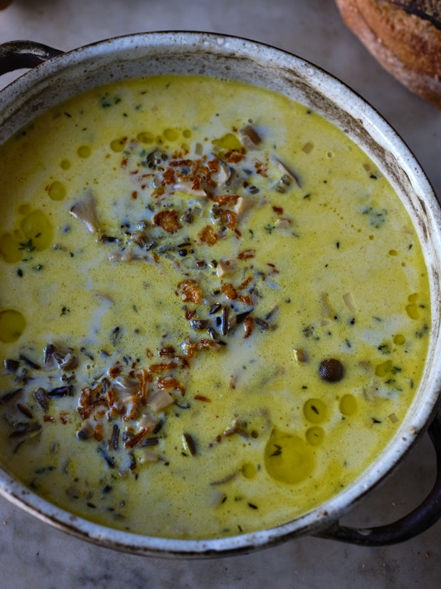 A pot of creamy wild rice soup in a rustic pot.