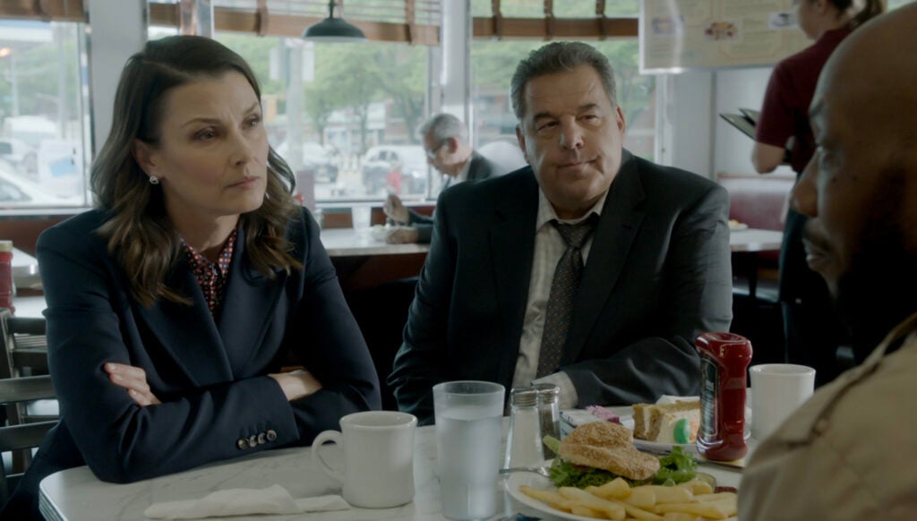 Erin and Anthony meet with someone at a restaurant on Blue Bloods Season 14 Episode 15