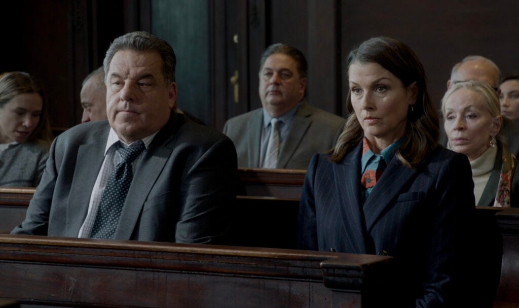 Erin and Anthony sitting together in pews on Blue Bloods Season 14 Episode 13