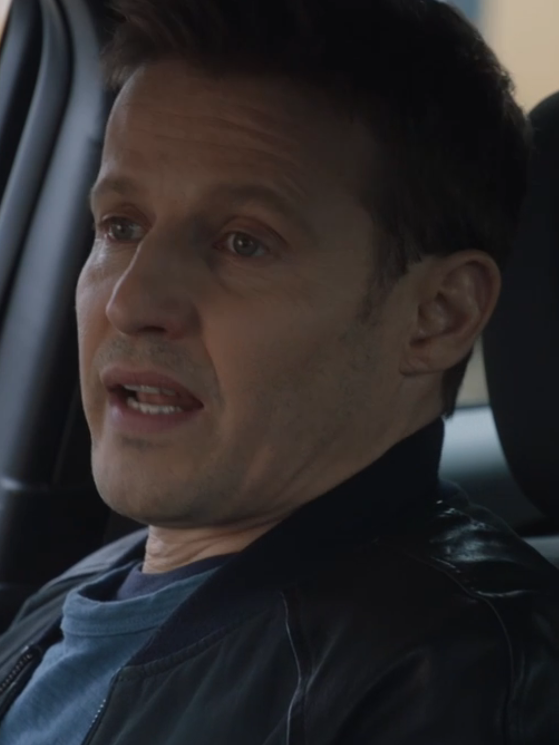 Joe looks at Jamie who is talking to him while riding together on Blue Bloods Season 14 Episode 11