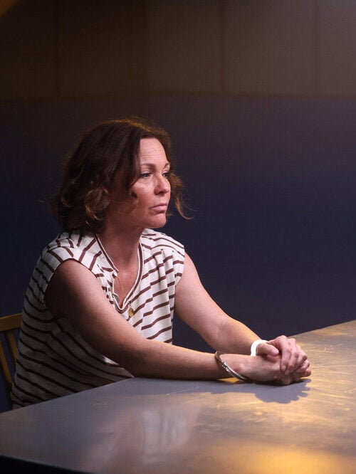 Margaret sits in an interrogation room.