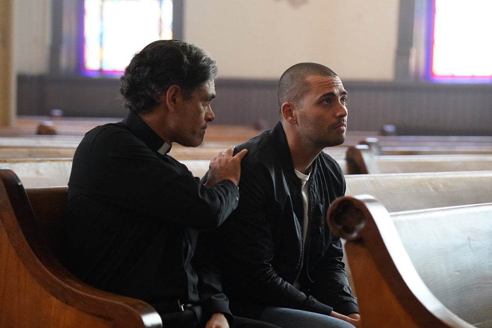 Torres speaks to the priest.