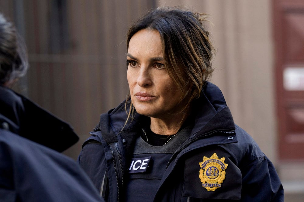 Benson wearing a police vest and uniform while looking determined