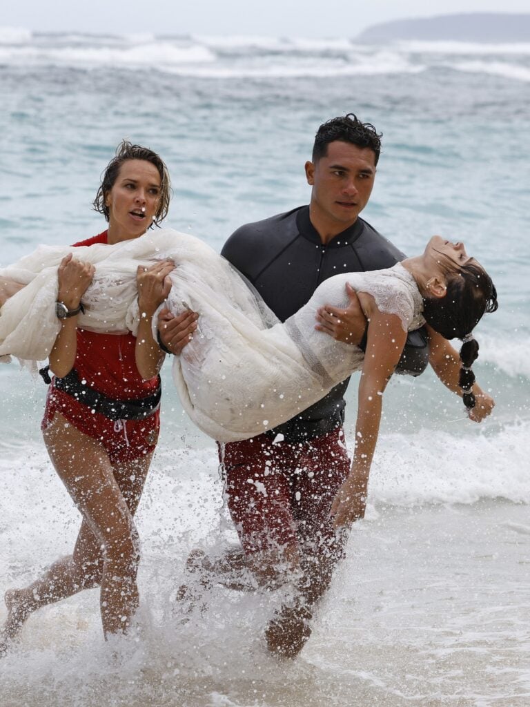 The team helps a woman out of the water during Rescue HI-Surf Season 1 Episode 7.