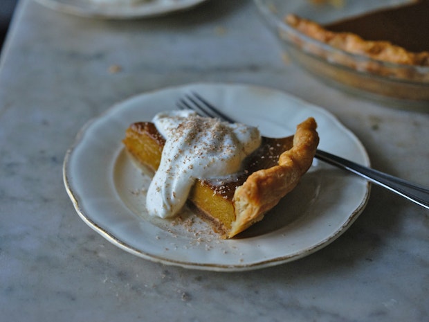 a perfect slice of pumpkin pie topped with whipped cream