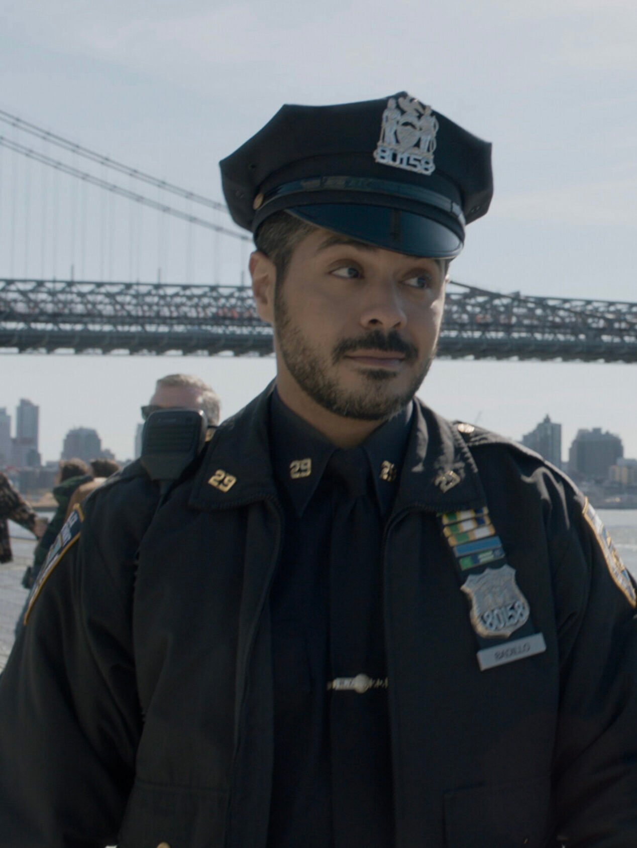 Eddie and Badillo in uniform standing in front of the bridge on Blue Bloods Season 14 Episode 13