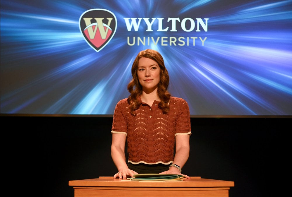 Phoebe presents in front of a screen with a Wylton University logo