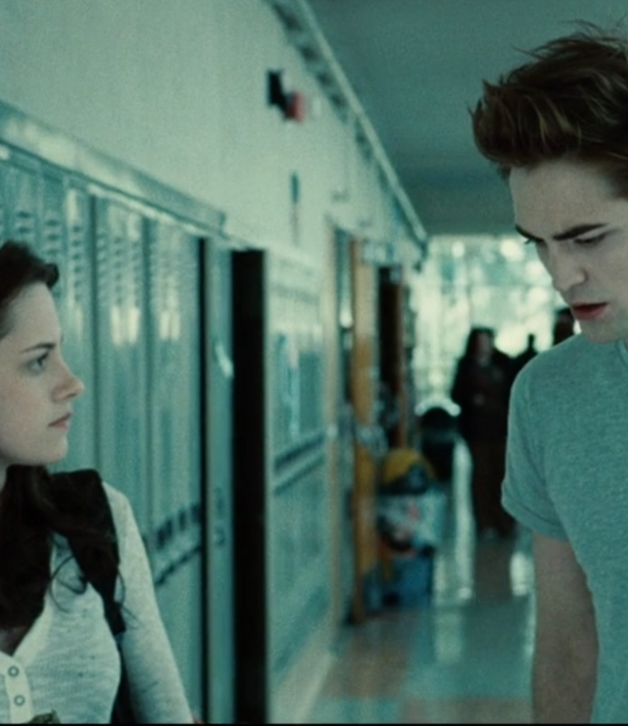 Bella and Edward chat in the hallway of their school.