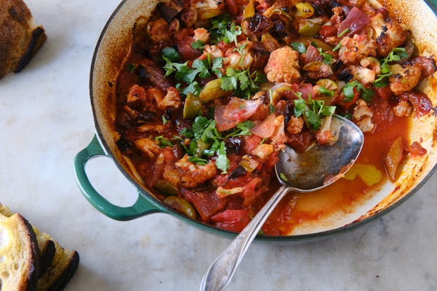 cauliflower caponata in a serving dish alongside bread