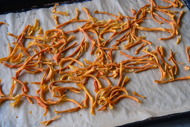 dry citrus peel on a parchment-lined baking sheet