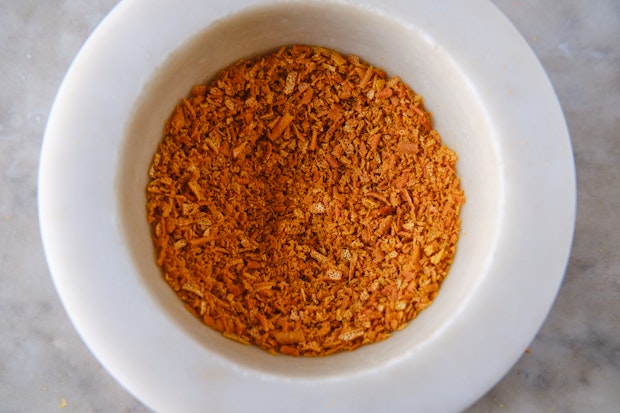 dried citrus peel after being pounded into small flecks in a mortar and pestle